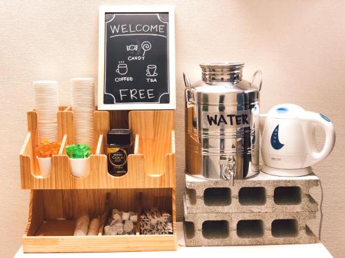 a wooden box with a coffee maker and a sign at ONE HOSTEL Himeji ワンホステル姫路 in Himeji
