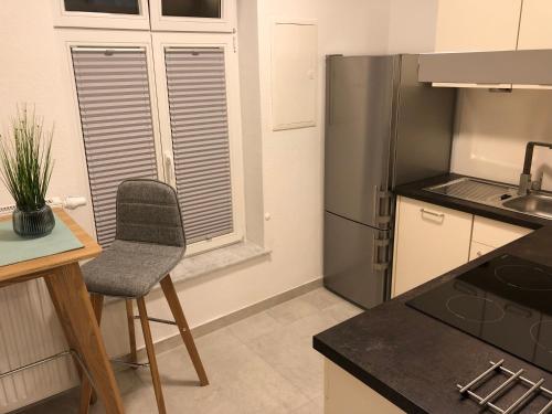 cocina con silla y nevera en Apartment am Schloßplatz Erlangen, en Erlangen