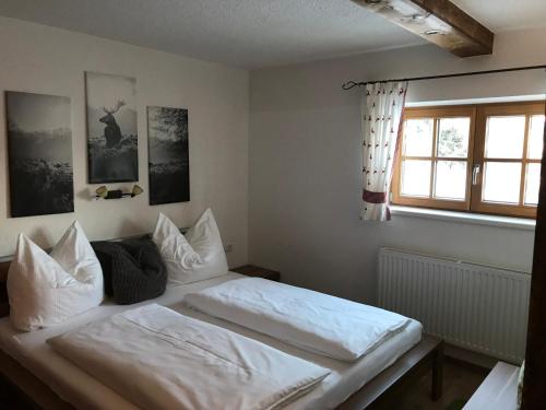 a bedroom with a bed with white sheets and a window at Apart Lisi in Fügenberg