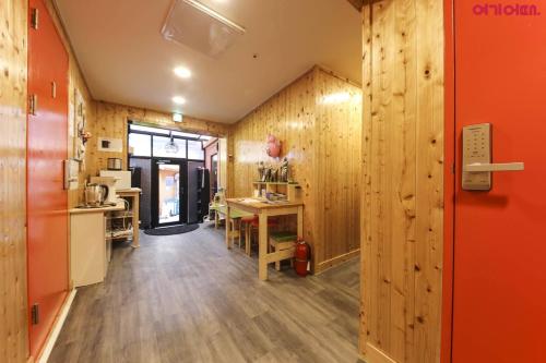 um quarto com paredes de madeira e uma cozinha com uma mesa em Seoul Station R Guesthouse em Seul