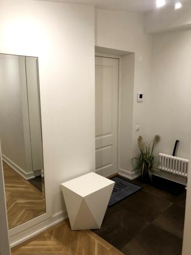 a white stool in a room with a mirror at Great apartament in a heart of Tallinn in Tallinn