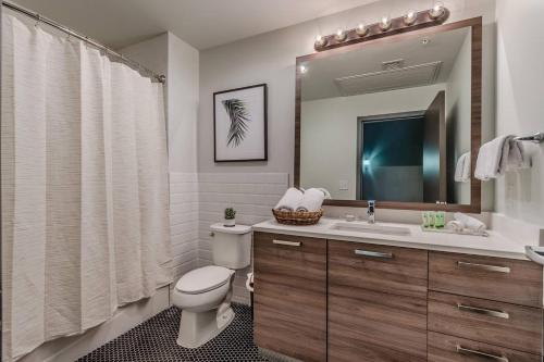 a bathroom with a toilet and a sink and a mirror at Abode Dallas - Downtown Convention Center in Dallas