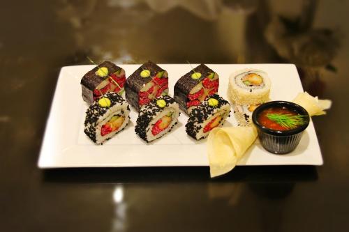 a white plate with sushi on a table at Carawan Al Fahad Hotel in Riyadh