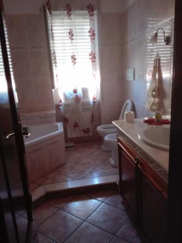 a bathroom with a tub and a toilet and a sink at B&B melody in Fiumicino