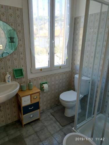 a bathroom with a toilet and a sink and a window at Ca' Federica in Vallecrosia