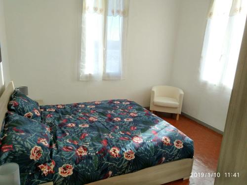 a bedroom with a bed with a floral bedspread at Ca' Federica in Vallecrosia