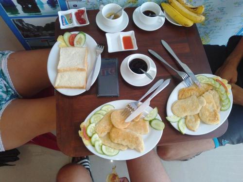 una persona sentada en una mesa con platos de comida en Tom's Family Hotel en Ha Long