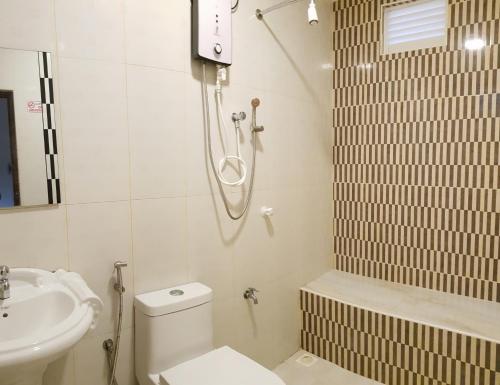 a bathroom with a shower and a toilet and a sink at Hulhan'gu Lodge in Himmafushi