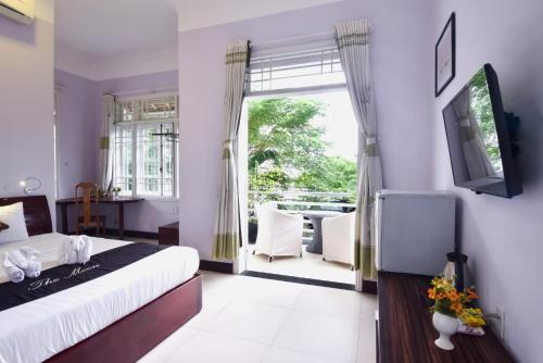 a bedroom with a bed and a large window at The Moon Villa Hoi An in Hoi An