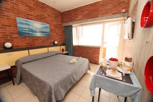 a bedroom with a bed and a table with a table sidx sidx sidx at Hotel Marina in Marina di Massa