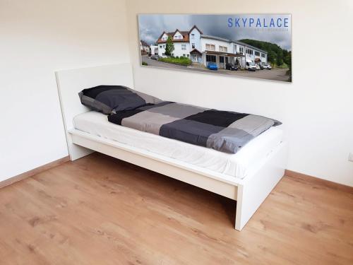 a white bed in a room with a picture on the wall at Monteurzimmer Obersulm in Obersulm