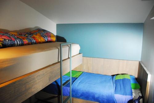 una camera con 2 letti a castello e una parete blu di B&B Het Schaliënhof a Veurne