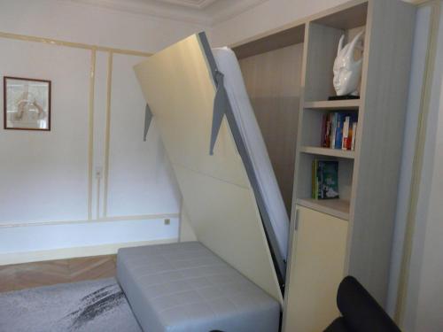 a room with a book shelf and a stair case at Le Beau Site - Studio in Aix-les-Bains