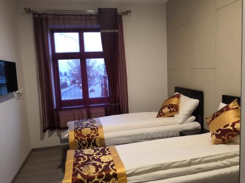two beds in a room with a window at Sun-House Pension&Restaurant -ParkingFree- in Prague