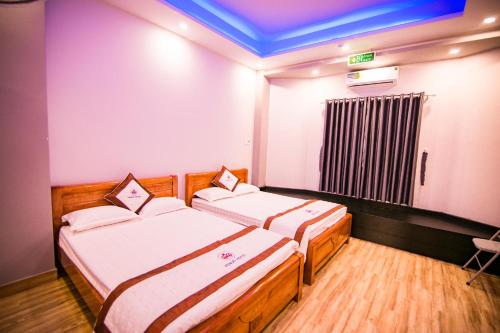 um quarto com duas camas e uma janela com aperitivo em SUNNY HOTEL em Quy Nhon