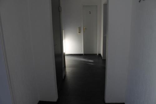 an empty hallway with white walls and a hallway with doors at Fewo Seifert in Schortens