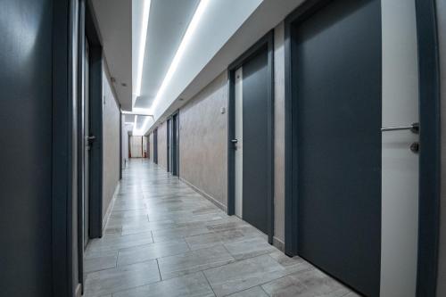 a hallway with black doors and a tile floor at Hotel Dunav Požarevac in Požarevac