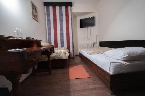 a bedroom with a piano and a bed and a desk at Hotel Dunav Požarevac in Požarevac