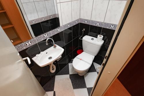 a small bathroom with a toilet and a sink at Hotel Dunav Požarevac in Požarevac