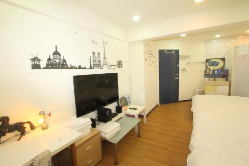 a bedroom with a bed and a tv on a wall at Sea Keelung in Keelung