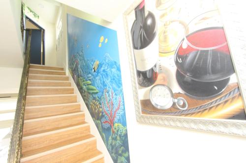 a hallway with a painting of a staircase and a painting of a kitchen at Sea Keelung in Keelung