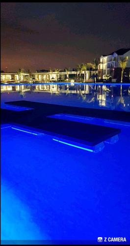 a large swimming pool at night with blue lights at The Blyde - Crystal Lagoon Penthouse Apartment in Pretoria
