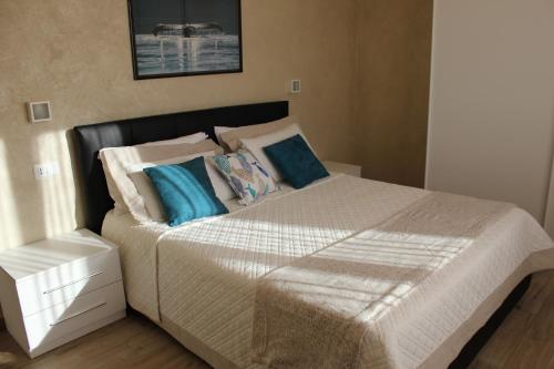 a bedroom with a large bed with blue pillows at "Home away from home" in Monterosso al Mare