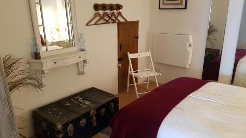 a bedroom with a bed and a chair and a mirror at Cortes de la Frontera Townhouse in Cortes de la Frontera