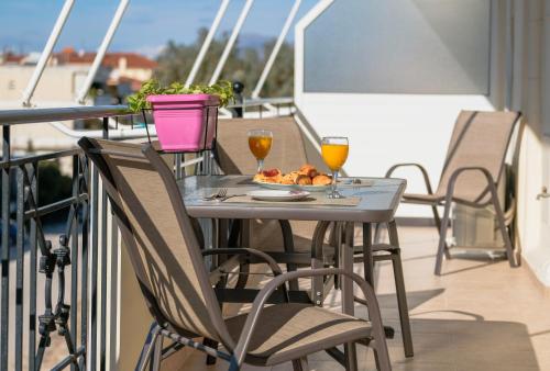 a table with two glasses of wine and a plate of food at Nafplio view in Nafplio