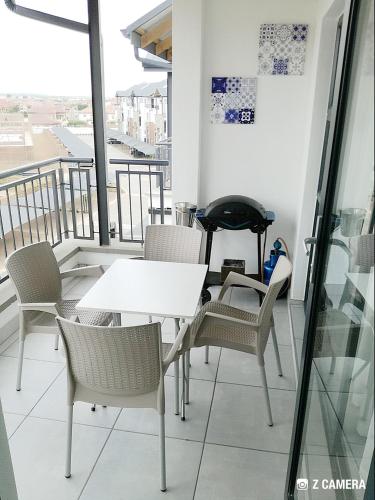 a white table and chairs on a balcony at The Blyde - Crystal Lagoon Penthouse Apartment in Pretoria