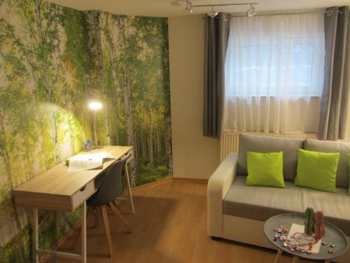 a living room with a couch and a desk at Wohnung im Dreistädteeck in Nürnberg