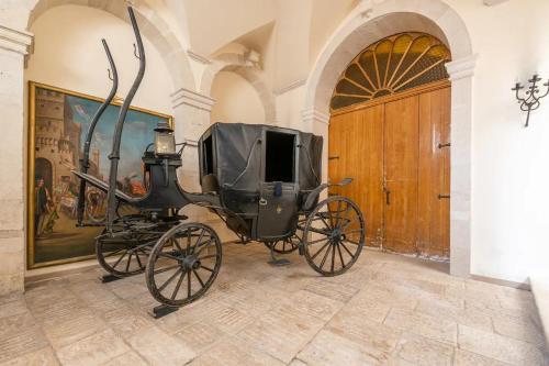 a horse drawn carriage parked in a room at Palazzo Framarino dei Malatesta - Noble Floor - XIV Century in Giovinazzo