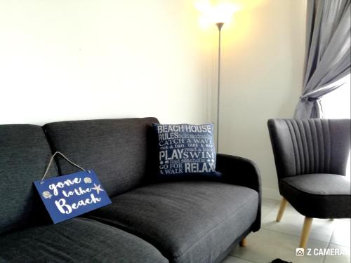 a living room with a gray couch with pillows at The Blyde - Crystal Lagoon Penthouse Apartment in Pretoria