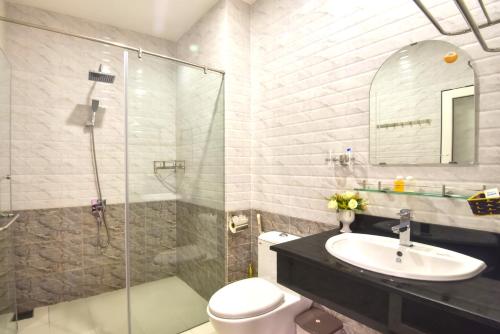 een badkamer met een douche, een toilet en een wastafel bij The Moon Villa Hoi An in Hội An