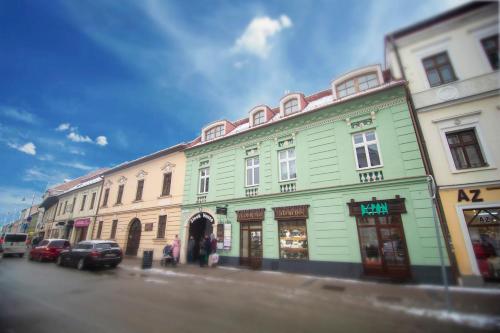a green building on the side of a street at Penzion Moyzes in Banská Bystrica