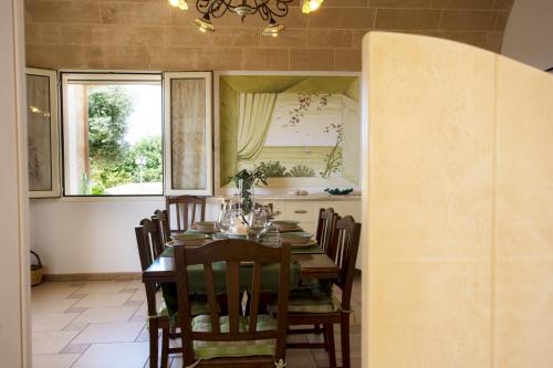 a dining room with a table and chairs and a window at Le Gioie - Villa Macchia Mediterranea - Splendida villa vista mare immersa nel verde in Torre Pali 