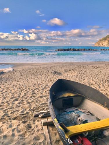a boat on a sandy beach with the ocean at Foglie d'Argento in Moneglia