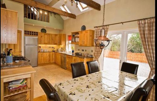 a kitchen with a table and chairs and a table and a kitchen with at Red Deer Cottage near Connemara National Park in Letterfrack in Letterfrack