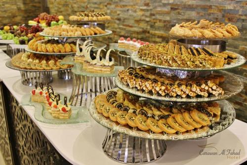 a table with several plates of desserts and pies at Carawan Al Fahad Hotel in Riyadh