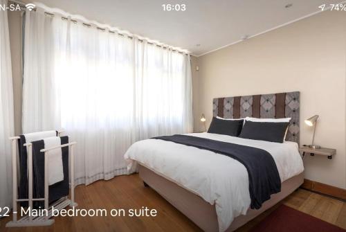 1 dormitorio con 1 cama grande y ventana grande en Forest Haven, en Johannesburgo