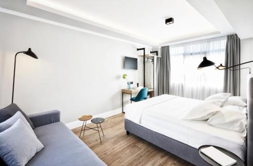 1 dormitorio con 1 cama y 1 sofá en The Artist Athens, en Atenas