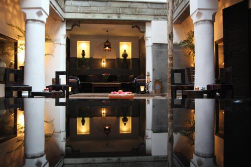 a lobby with a reflection in a pool of water at Riad Terra Bahia in Marrakech
