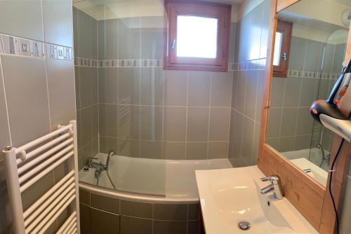een badkamer met een wastafel en een bad bij Boost Your Immo Chalet des Rennes 83 in Vars