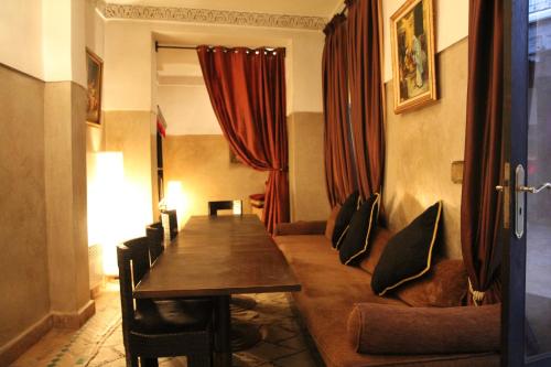 a dining room with a table and a couch at Riad Terra Bahia in Marrakech