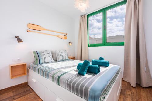 Vivienda Vacacional Namana Beach في كوستا تاغيسي: غرفة نوم عليها سرير ومخدات زرقاء