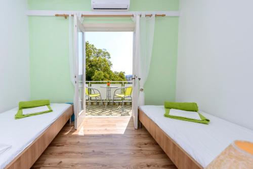 een kamer met 2 bedden en een balkon bij Guest House Villa Bellevue 2 in Cavtat