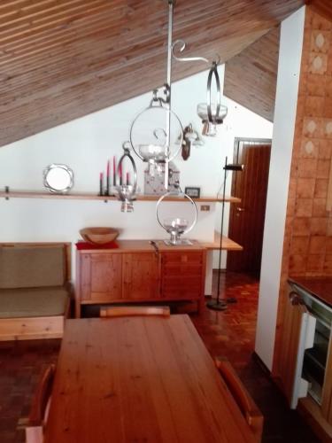 a dining room with a table and a chandelier at Mansarda condominio Royal in Valtournenche