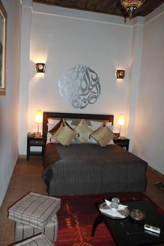 a bedroom with a large bed and a table at Riad Terra Bahia in Marrakech