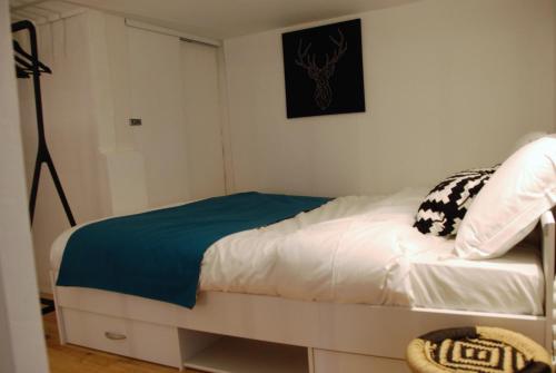a bedroom with a white bed with a blue blanket at Le typique - coeur de ville in Toulouse