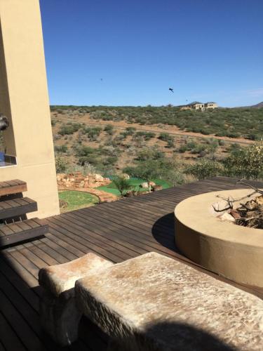 eine Holzterrasse mit Blick auf die Wüste in der Unterkunft Windhoek Rural Self Catering in Voigtland